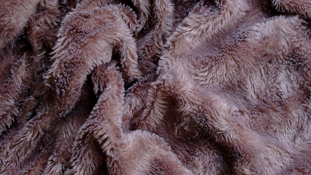 Warme en zachte geweven gerimpelde bontbruine katoenen dekenachtergrond. bovenaanzicht
