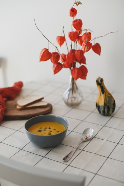 Warme gezonde vegetarische pompoenroomsoep met zaden op tafel