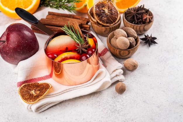 Warme glühwein met fruit en specerijen in een koperen pot