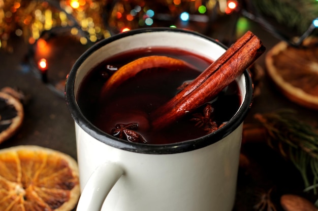 Warme glühwein met kaneel en oranje close-up op een donkere achtergrond. Kerstmis. Nieuwjaar.