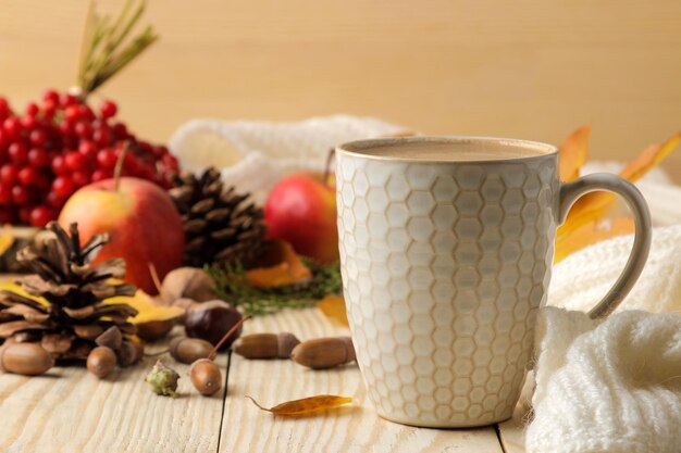 Warme herfst drink koffie of cacao met gele bladeren en decoratieve pompoenen eikels en appels op een natuurlijke houten tafel herfst compositie