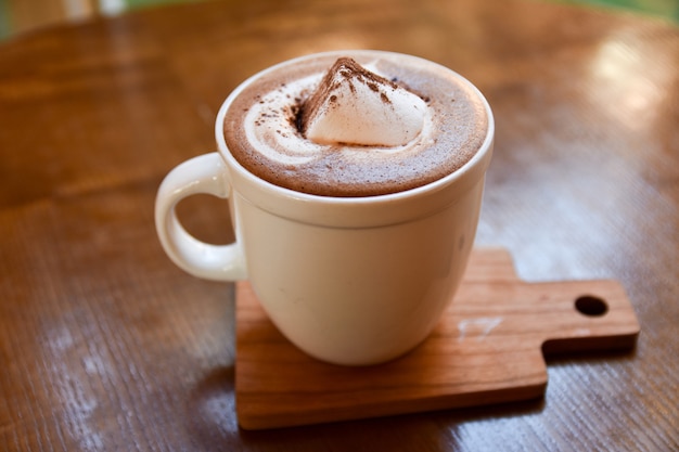 warme koffie beker op houten tafel op bruine achtergrond