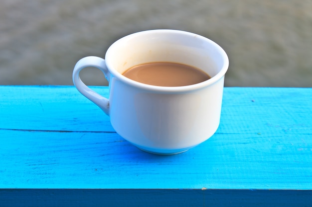 warme koffie in witte kop op houten