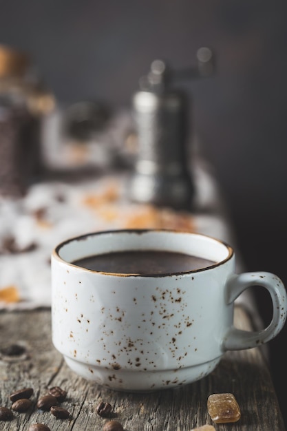 Warme koffiekop en koffiebonen op de houten tafel, rustieke stijl