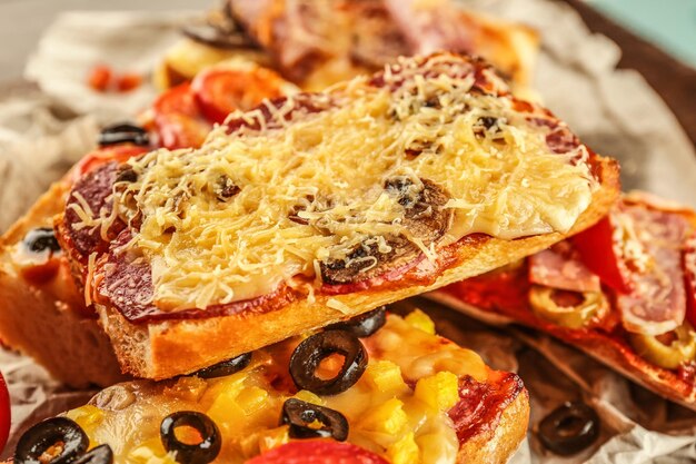 Warme pizza baguette met salami paddestoelen en kaas op een houten tafel