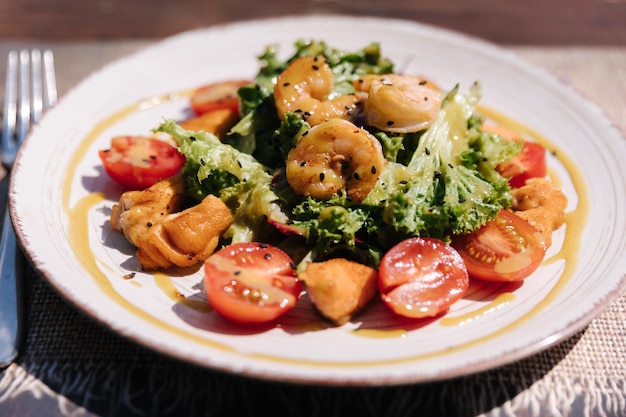 Warme salade met garnalen en zalmsaus en parmezaanse kaas bovenop gezond eten buiten