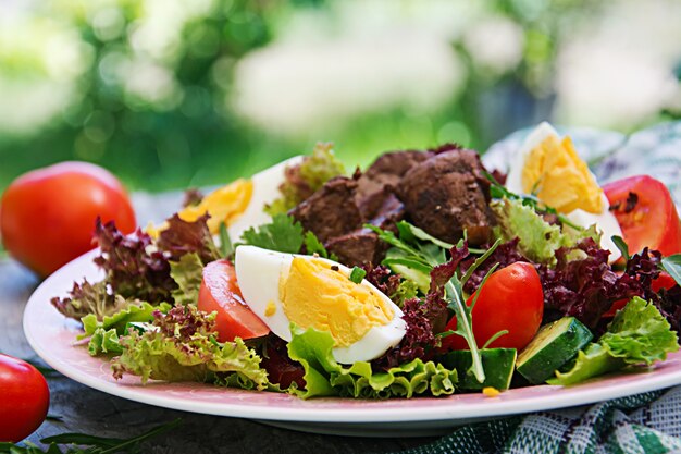 Warme salade van kippenlever, tomaat, komkommer en eieren. Gezond diner. Dieetmenu