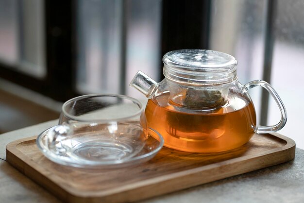 Warme thee in een theepot en kopje op een houten dienblad