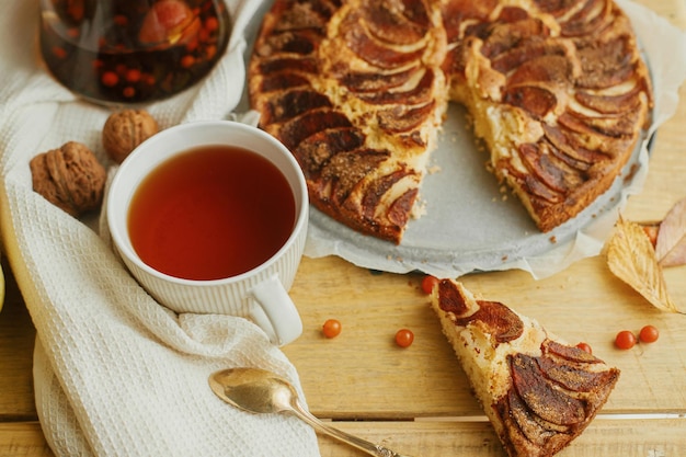 Warme thee in stijlvolle kop op rustieke tafel met vers gebakken appeltaart met kaneel Hygge stilleven