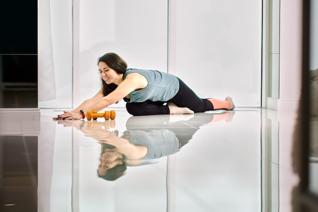 Warme vloer en jonge vrouw maakt oefeningen en stretching