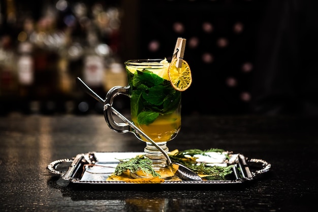 Согревающий алкогольный коктейль с мятно-медовым сиропом Банка мандарина на прилавке на темном фоне Сангрия пунш