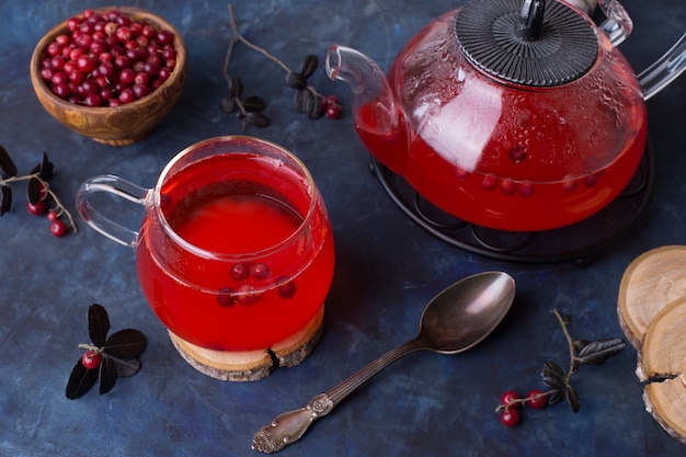 Warming cranberry tea in a glass Cup on a dark table