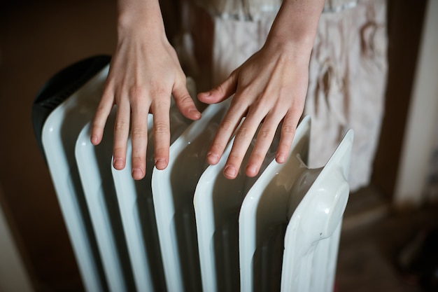 Photo warming his hands over a radiator.