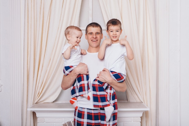 Warming and relaxing by the fireplace. parents with their son's child hug. The concept of family, motherhood, interior, home, childhood, mother's Day, the day of protection of children