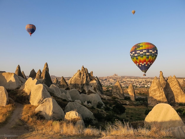 Foto warmluchtballonnen vliegen over rotsformaties tegen de lucht