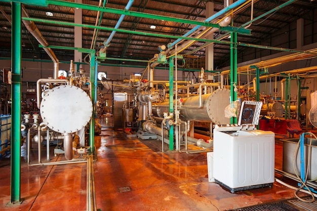 Warmtewisselaar bij isolatie in procesgebied van pijpleiding die glanzend roestvrij chemisch product in fabriek stroomt;