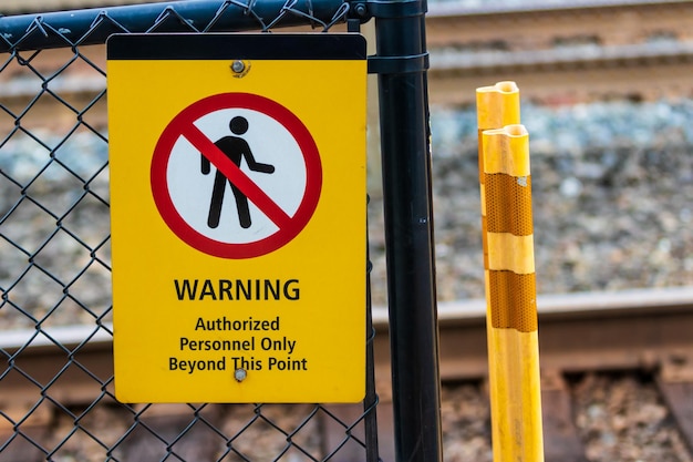 Photo warning authorized personnel sign on a chain link fence