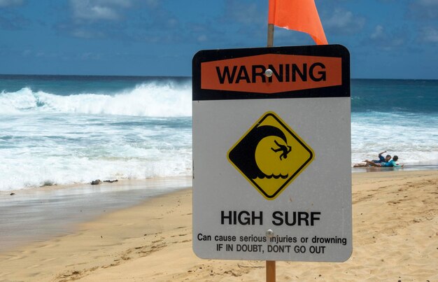 Photo warning sign on beach against sky