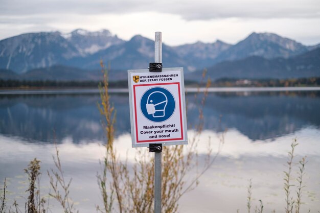 Photo warning sign by lake against sky
