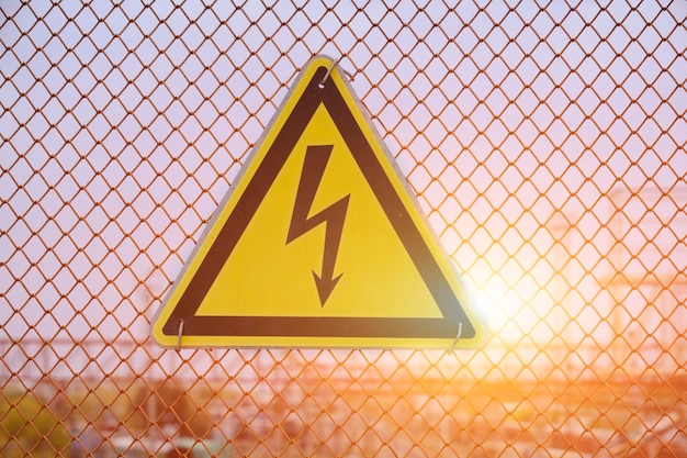 Warning sign form of lightning bolt on a yellow high voltage signBright solar illumination