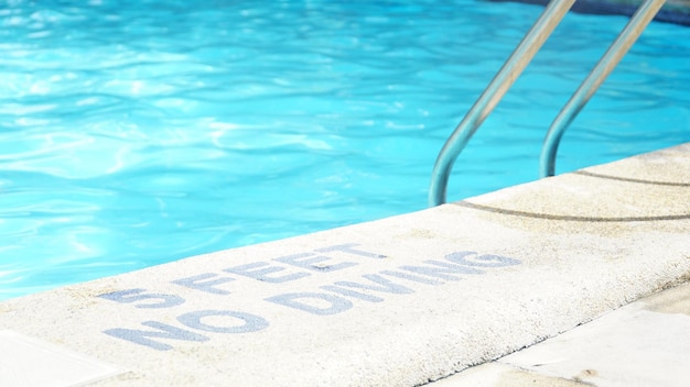 warning sign at poolside during sunny day