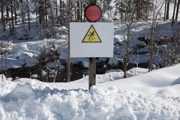 写真 背景の氷と雪に落ちるのを警戒する警告信号