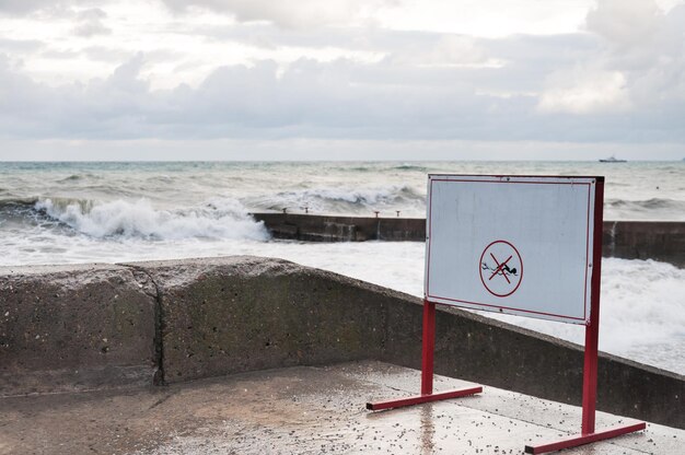 Warning tablet on the waterfront in the storm