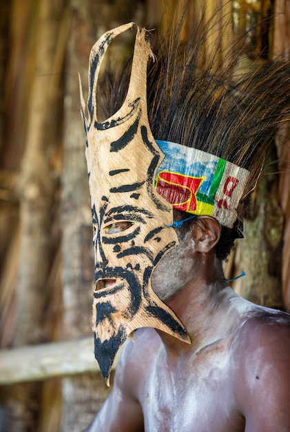 Photo warrior of the asmat tribe in a battle mask.