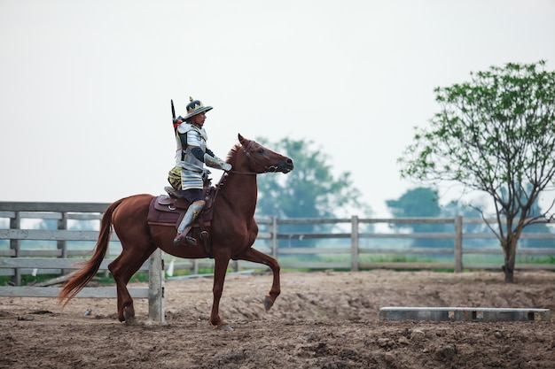 農場で馬に乗っている伝統的な装甲の戦士