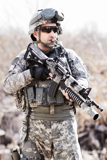 전쟁의 전사 사막 환경에서 손에 총을 들고 서 있는 군인