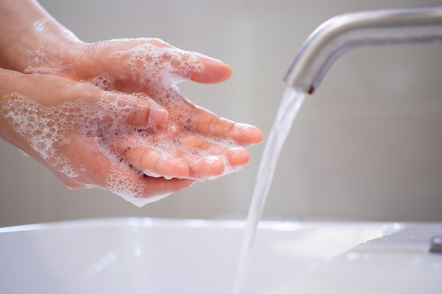 Was uw handen met zeep, voorkom dat virussen en bacteriën in de kraan komen met stromend water. Goede hygiëne voor het eten of hanteren van openbare voorwerpen