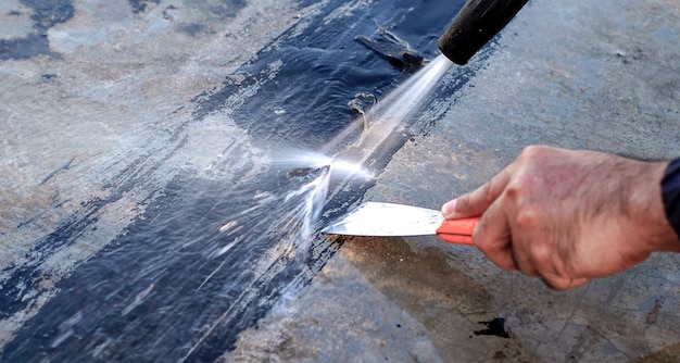 セメント床を高圧クリーナーで洗うひびの入ったデッキをステンレス鋼のこてで修理する