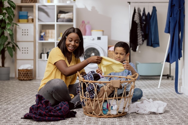 Wash clothes in washing machine laundry room bathroom women and little boy spend time talking