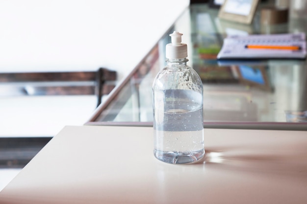 Вымойте спиртовой гель для рук или диспенсер для бутылочек с дезинфицирующим средством в офисе. Концепция гигиены и здоровья