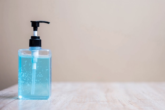 Wash hand alcohol gel or sanitizer bottle on wooden table background