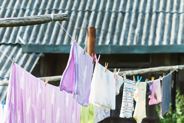 Фото Промытое красочное хлопковое белье, висящее на веревке, сушка текстиля на заднем дворе.