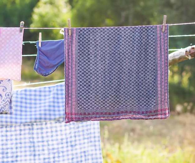 Photo washed colorful cotton laundry hanging on the rope textile drying on backyard