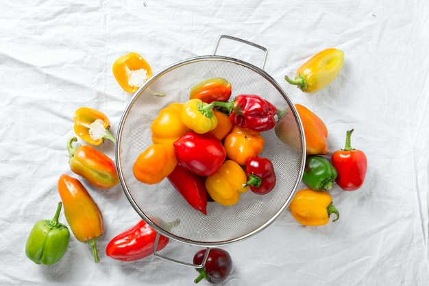 Washed yellow, red and green bell peppers in sieve