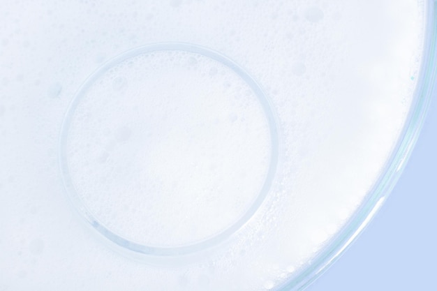 Washing agent foam in a Petri dish On a blue background