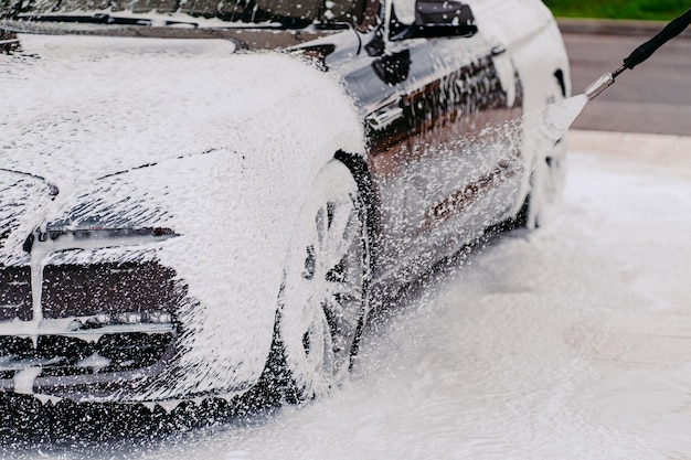 Washing black car Automobile cleaning with foam water Transport cleaning concept Carwash at station Cleaning service