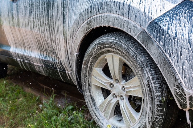 Washing the car, car wheel in foam