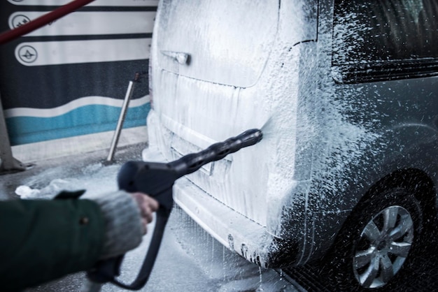 Washing car with soap. Close up clean car concept at car wash.