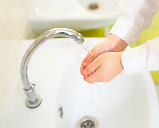 Фото Мытье рук детей под краном в ванной