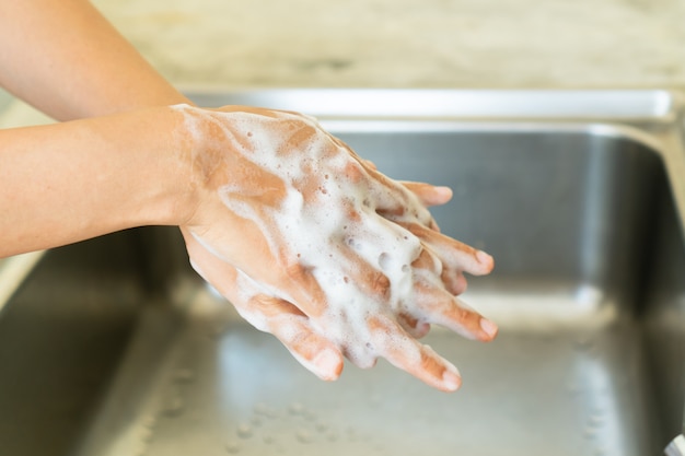 Foto lavarsi / pulire le mani con sapone. concetto di disinfezione da batteri o virus. assistenza sanitaria, da vicino