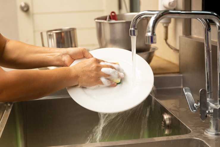 Photo washing dirty plate in kitchen sink