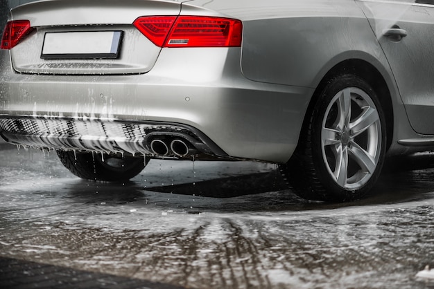 Photo washing grey car in the car wash indoors. - back headlights view