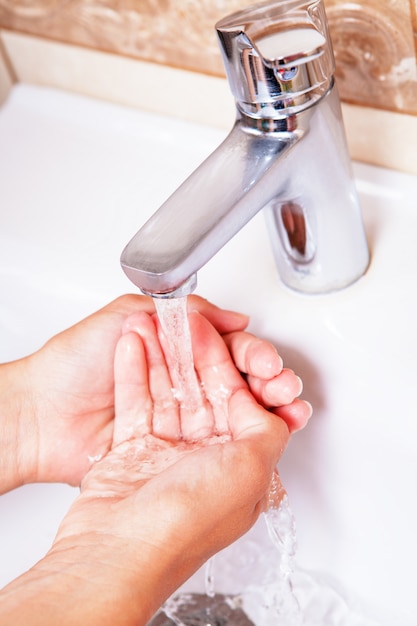 Foto lavarsi le mani sotto l'acqua del rubinetto