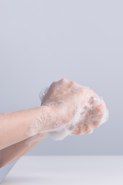 Washing hands Asian young woman using liquid soap to wash hands concept of hygiene to protective pandemic coronavirus isolated on gray white background close up