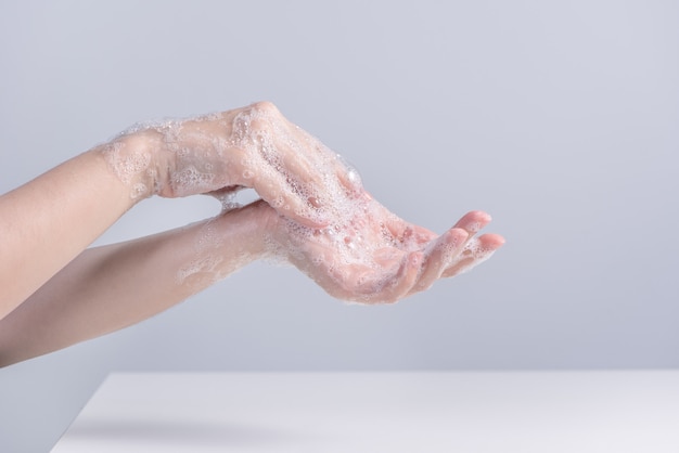 Washing hands. Asian young woman using liquid soap to wash hands, concept of hygiene