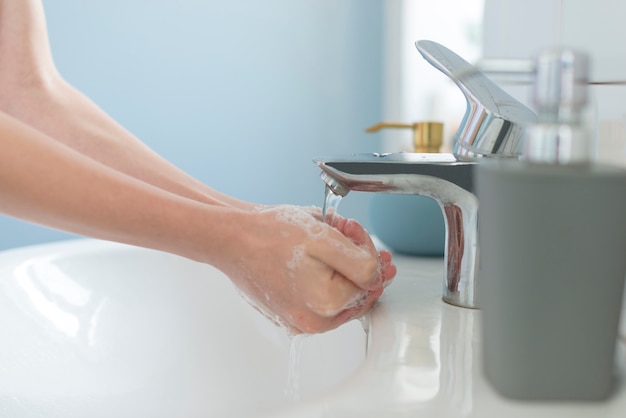 Lavarsi le mani nel lavandino con acqua e sapone